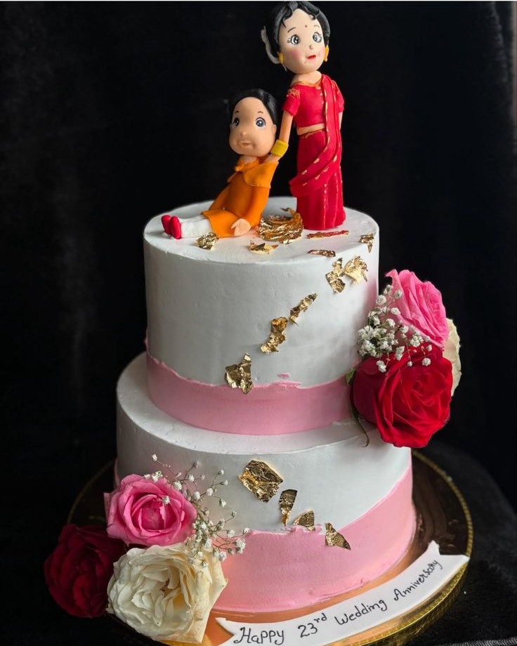 Romantic two-tier anniversary cake with floral accents and gold leaf details