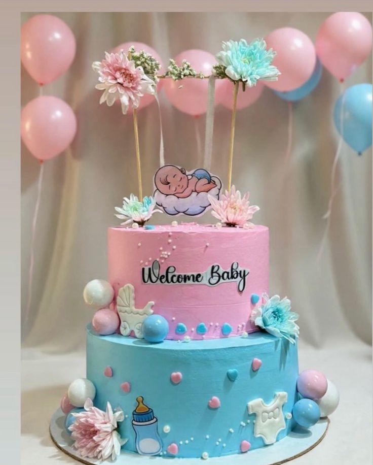Pastel pink and blue baby shower tier cake with welcome baby topper